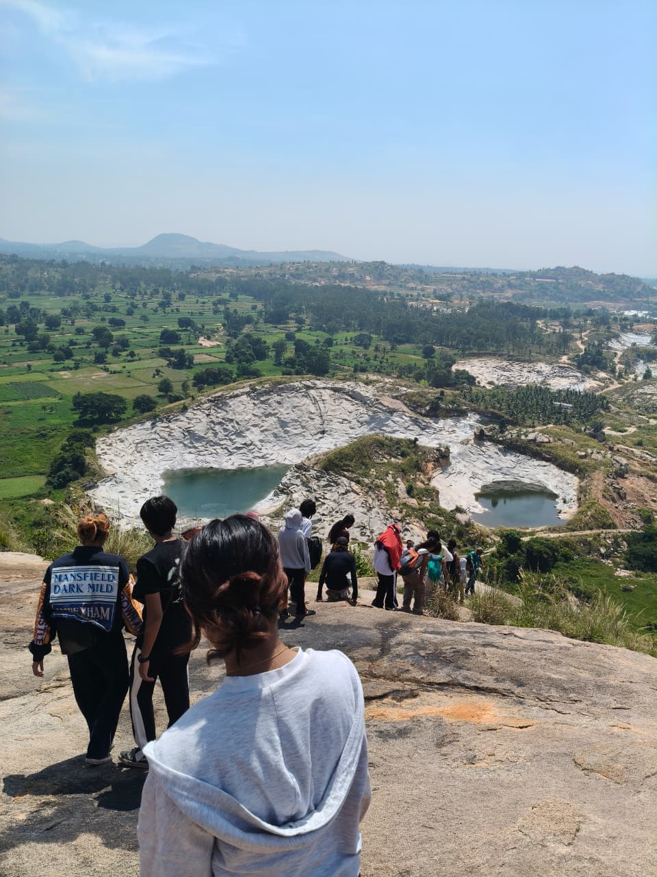Panoramic summit viewpoint looking out over natural granite rock formations, turquoise lakes, and green valleys