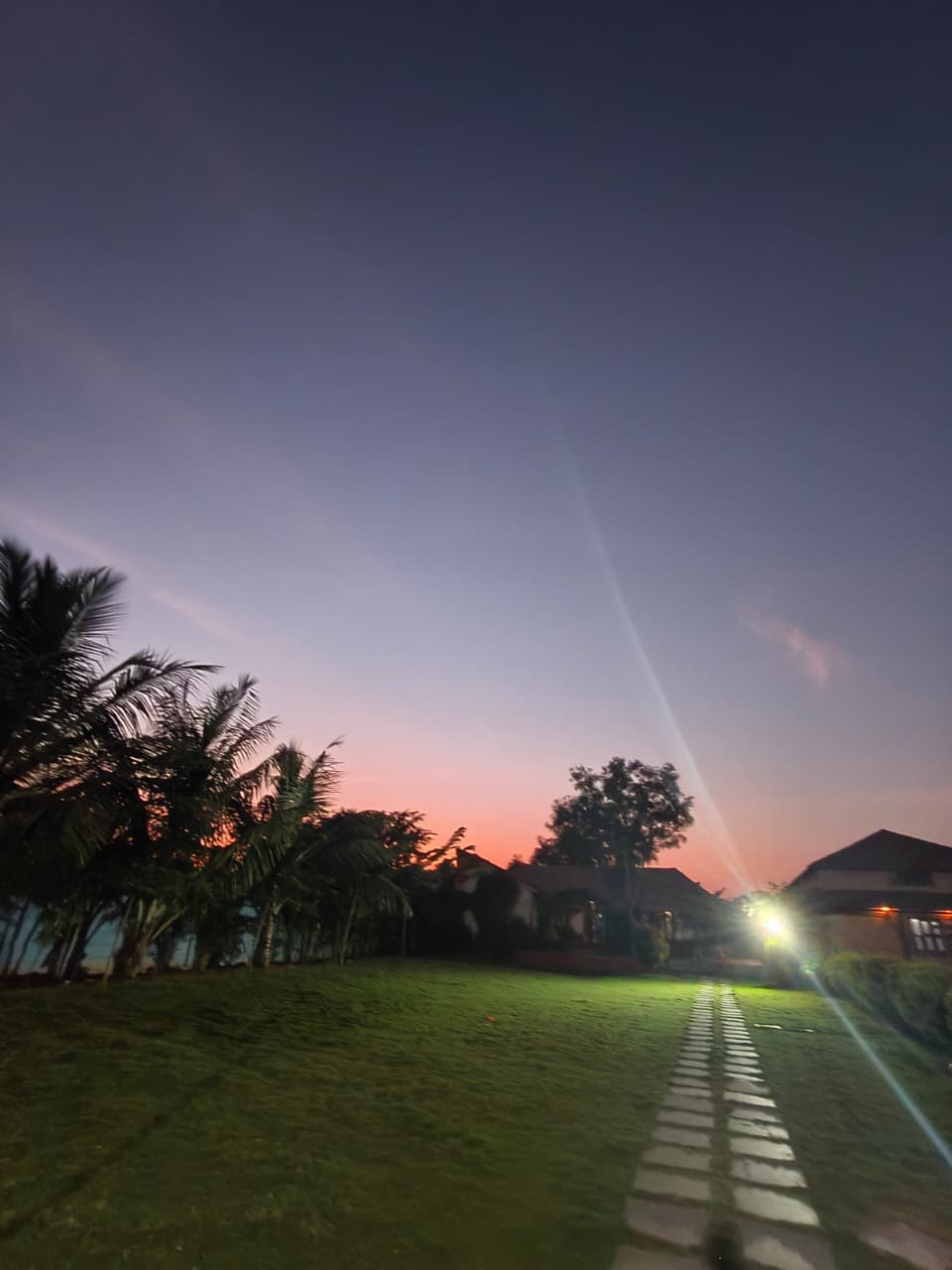 Peaceful twilight glow casting vibrant orange and purple hues across the manicured lawns and cottages